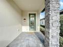 Front entrance with a green door and stone column at 7959 Delwin Ln, Kissimmee, FL 34747