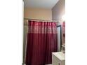 Bathroom with a burgundy shower curtain and white vanity at 116 S 4Th St, Haines City, FL 33844