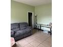 Living room featuring a gray couch and tiled floors at 116 S 4Th St, Haines City, FL 33844