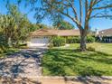 House exterior showcasing a spacious yard and driveway at 1416 Wood Lake Cir, St Cloud, FL 34772