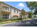 Townhouses with balconies, manicured landscaping, and a tree-lined street at 701 Westpark Way # 202, Celebration, FL 34747