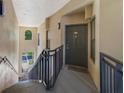 Clean, well-lit stairwell with dark metal railings leading to a condo entrance at 701 Westpark Way # 202, Celebration, FL 34747