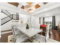 Modern dining room with white table, chandelier, and access to game room at 9111 Outlook Rock Trl, Windermere, FL 34786