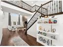 Elegant entryway with hardwood floors, a staircase with wrought iron railing, and built-in shelving at 9111 Outlook Rock Trl, Windermere, FL 34786