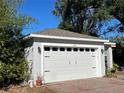 White two-car garage with black accents and a brick paved driveway at 1493 Park Dr, Casselberry, FL 32707