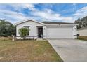 White house with black accents, two-car garage, and landscaped lawn at 608 Gila Dr, Kissimmee, FL 34759