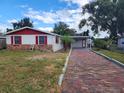 Single-story home with red shutters, brick accents, and a large front yard at 1427 Wilton Ave, Orlando, FL 32805