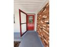 Open red front door of a house with a brick exterior wall at 1427 Wilton Ave, Orlando, FL 32805