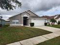Charming single-story home with a well-maintained lawn and attached garage at 2528 Chatham Cir, Kissimmee, FL 34746