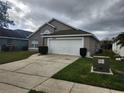 Exterior view of a one-story home with an attached garage and driveway at 2528 Chatham Cir, Kissimmee, FL 34746