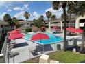 Community pool with red umbrellas and lounge chairs at 5245 W Irlo Bronson Memorial Hwy # 115, Kissimmee, FL 34746