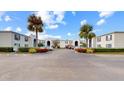 Community entrance and parking lot with tropical palm trees and landscaping at 1006 Plantation Dr # F12, Kissimmee, FL 34741