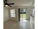 Living room with sliding glass doors leading to a balcony, ceiling fan, and tiled floor at 11562 Westwood Blvd # 914, Orlando, FL 32821