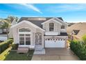 Two-story house with solar panels, a large front yard, a two-car garage, and a brick driveway at 2430 Berkshire Ct, Kissimmee, FL 34746