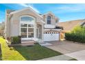 Two-story house with a large front yard, a two-car garage, and a brick driveway at 2430 Berkshire Ct, Kissimmee, FL 34746