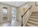 Welcoming foyer with decorative glass front door, view to bedroom, and stairway at 5414 Catmint Dr, Lake Hamilton, FL 33851