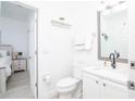 White bathroom with black accents and wood-look flooring, vanity with sink, toilet at 733 Calabria Ave, Davenport, FL 33897