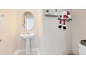 Small powder room with pedestal sink and decorative shelf at 2175 Old Mining Rd, Lakeland, FL 33801