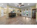 Open-concept living area with wood-look tile floors, breakfast bar, and access to backyard at 3305 Cat Brier Trl, Harmony, FL 34773