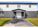 Modern home's front entrance with gray and white exterior and wooden walkway at 5155 Haywood Ruffin Rd, Saint Cloud, FL 34771