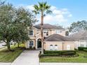 Two-story house with tan exterior, green door, and palm tree in front at 673 Copeland Dr, Haines City, FL 33844