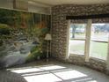 Living room features a nature mural and stone wall at 8286 County Road 109B, Lady Lake, FL 32159