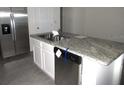 Kitchen island with granite countertop and stainless steel dishwasher at 1366 Yellow Finch Dr, Davenport, FL 33837