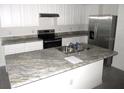 Modern kitchen with stainless steel appliances and granite countertops at 1366 Yellow Finch Dr, Davenport, FL 33837