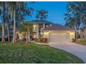 Two-story house with a large yard, attached garage, and a charming front entrance at 1465 Riviera Dr, Kissimmee, FL 34744