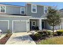 Two-story townhome with gray exterior, two-car garage, and front porch at 1861 Roosevelt Pl, St Cloud, FL 34769