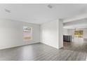 Open living area with grey wood-look flooring and neutral walls at 249 Fig Ct, Kissimmee, FL 34759