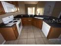 L-shaped kitchen with dark countertops, wood cabinets, and standard appliances at 2642 Rutledge Ct, Winter Haven, FL 33884