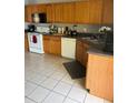 Kitchen features wood cabinets, tile floors, and ample counter space at 308 Coventry Estates Blvd, Deltona, FL 32725