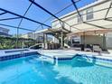 Inviting pool and spa with covered patio, outdoor seating, and lush landscaping at 4191 Oaktree Drive, Davenport, FL 33837
