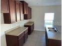 Kitchen with dark brown cabinets and granite countertops at 640 Spanish Pine Rd, Davenport, FL 33837