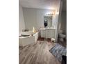 Bathroom with corner bathtub and wood-look flooring at 8185 County Road 109, Lady Lake, FL 32159