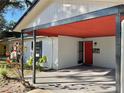 Inviting covered entryway with a red front door and landscaping at 916 S Park Ct, Kissimmee, FL 34741