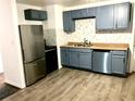 Modern kitchen featuring blue cabinets and stainless steel appliances at 916 S Park Ct, Kissimmee, FL 34741