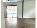 Bright living room with pool view and wood-look floors at 916 S Park Ct, Kissimmee, FL 34741