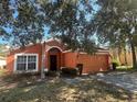 One-story house with orange exterior, arched entryway and landscaping at 922 Sandy Ridge Drive Dr, Davenport, FL 33896