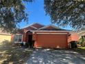 Front view of a charming one-story house with a spacious driveway at 922 Sandy Ridge Drive Dr, Davenport, FL 33896