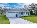 Newly built single story home with gray roof, white walls, and a paved driveway at 2828 Sequoyah Dr, Haines City, FL 33844