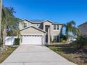 Two-story house with a neutral exterior, a three-car garage, and palm trees at 513 Big Black Way, Kissimmee, FL 34759