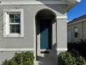 Front entrance with arched entryway and teal door at 2843 Turnstone Run, Harmony, FL 34773