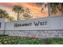 Harmony West community entrance sign with stone and landscaping at 2937 Hooded Crane Cv, Harmony, FL 34773