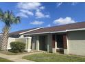 Exterior view of a light green house with a brown roof, palm trees, and a landscaped yard at 34 Pine Island Cir, Kissimmee, FL 34743