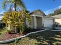 House with a palm tree and well-maintained landscaping at 449 Heather Hill Blvd, Davenport, FL 33837