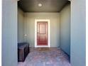 Front entry with a dark brown door and brick flooring at 4626 Terrasonesta Dr, Davenport, FL 33837