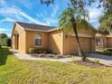 Tan house with a two-car garage and landscaped yard at 509 Millifiora Ln, Kissimmee, FL 34759