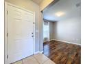 Entryway with white door, wood floors, and view into living room at 627 Lucerne Blvd, Winter Haven, FL 33881